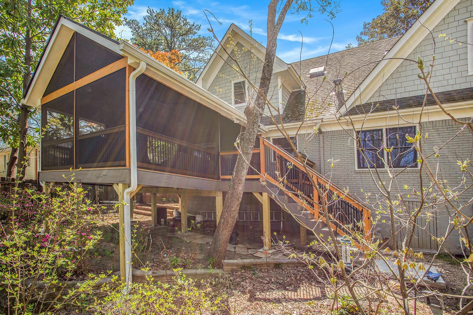 screened in porch on the back of a home with a staircase